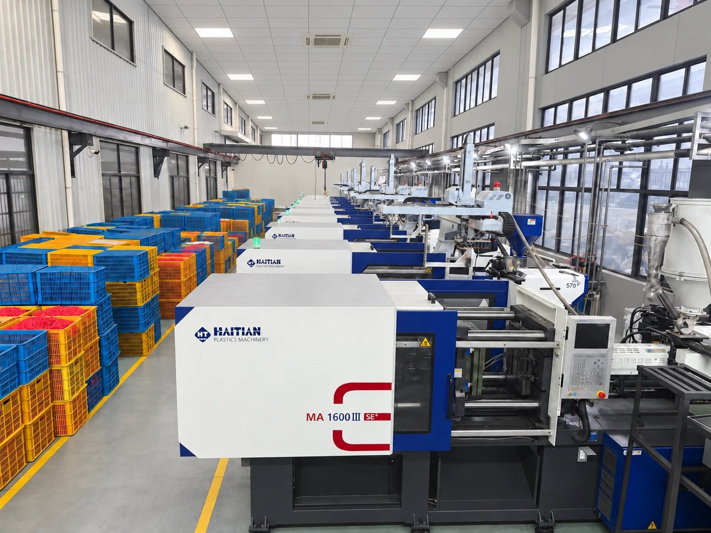 Injection moulding machines and coloured storage crates in the workshop